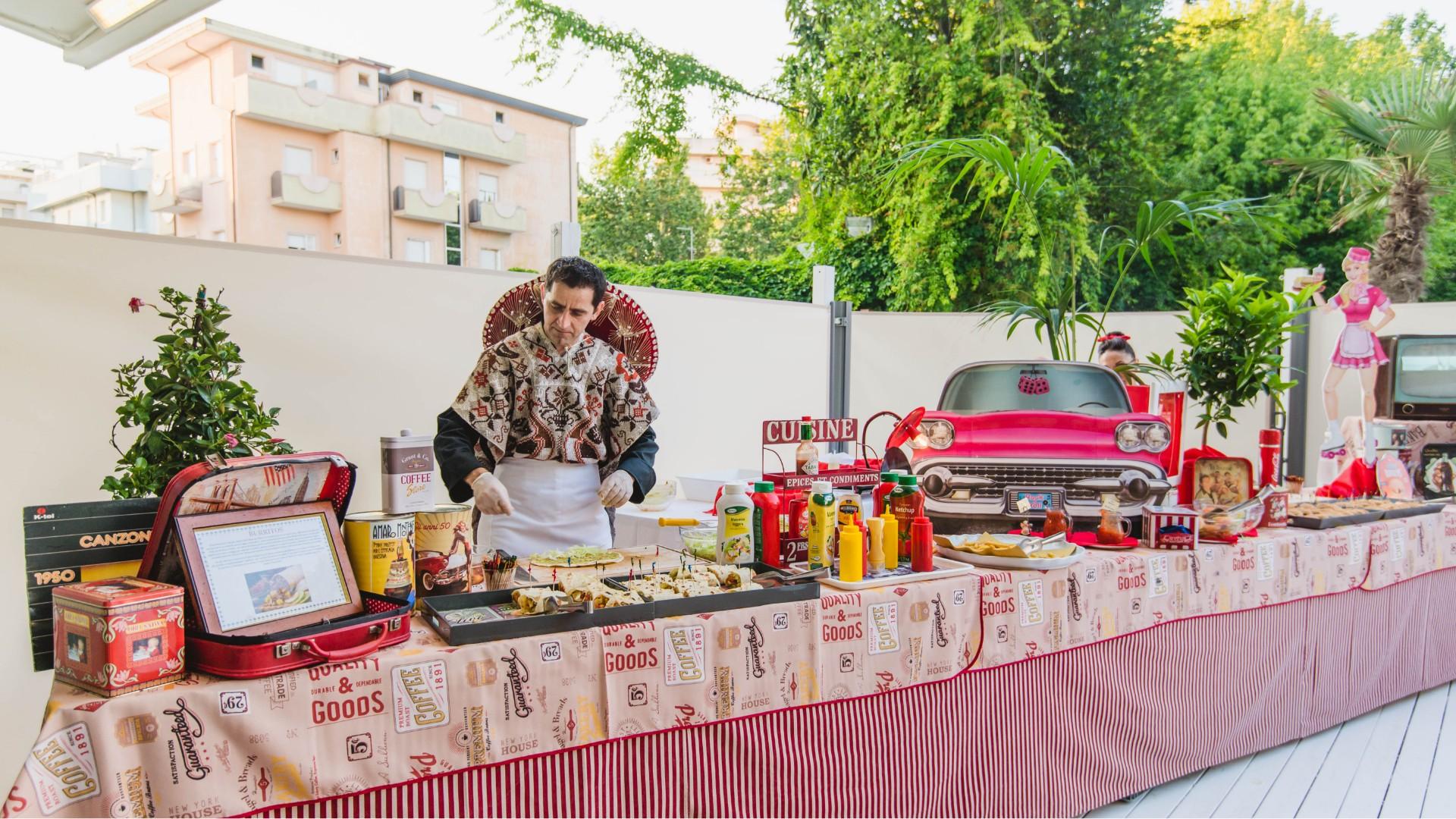 Buffet a tema retrò con decorazioni anni '50 e cibo vario.