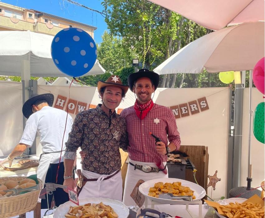 Due persone in abiti da cowboy a una festa con cibo e decorazioni.